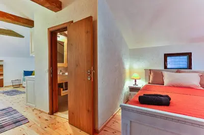 a bedroom with a large bed with a red blanket at Olea Apartments in Stari Bar