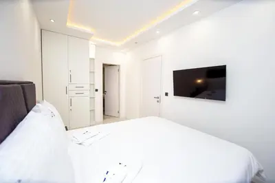 a white bedroom with a bed and a tv at Villa Aurora Azure - Luxury Infinity Pool Resort in Katun