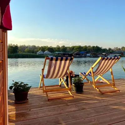 two chairs sitting on a dock next to the water at Zvoncica, Ada Bojana in Ada