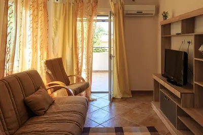 a living room with a couch and a television at Yu&li Rose Apartments Adriatic in Bar