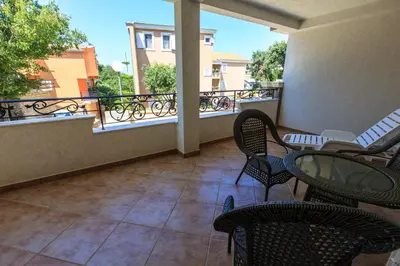 a balcony with chairs and tables on a building at Yu&li Rose Apartments Adriatic in Bar