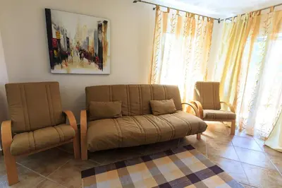 a living room with two chairs and a couch at Yu&li Rose Apartments Adriatic in Bar
