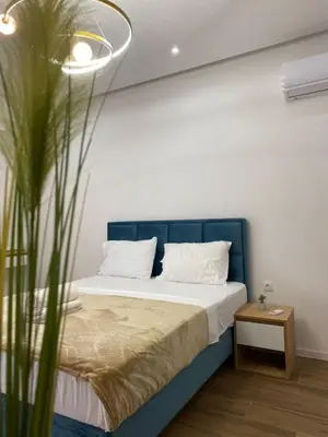 a bed with a blue headboard in a room at Morea Residence in Ulcinj