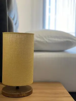 a lamp on a table in front of a bed at Morea Residence in Ulcinj