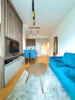 a living room with a blue couch and a table at Luxe Beachfront Stay in Bečići with Pool in Budva