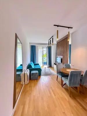 a room with a dining table and a bedroom at Luxe Beachfront Stay in Bečići with Pool in Budva