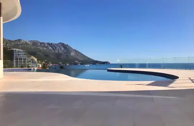 a swimming pool with a view of the ocean at Luxe Beachfront Stay in Bečići with Pool in Budva