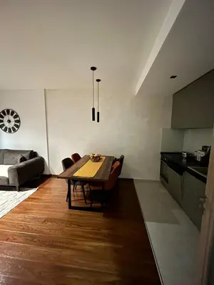 a living room with a table and a kitchen at Urban Apartment Master Quart in Podgorica