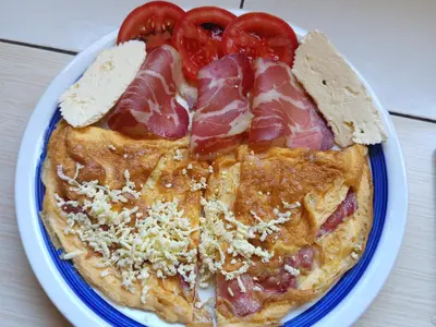 a plate of food with meat and tomatoes on it at Camp River in Virpazar