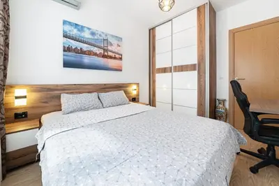 a bedroom with a white bed and a desk at Aurora Apartment 1 with Parking in Budva