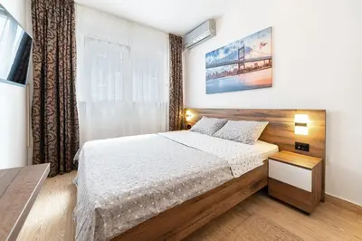 a bedroom with a bed and a large window at Aurora Apartment 1 with Parking in Budva