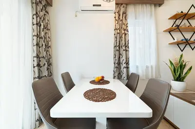 a dining room with a white table and chairs at Aurora Apartment 1 with Parking in Budva