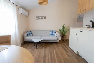 a living room with a couch and a table at Bright & Cozy Apartment in quiet area near Airport in Golubovci