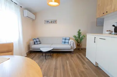 a living room with a couch and a table at Bright & Cozy Apartment in quiet area near Airport in Golubovci
