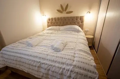 a bedroom with a bed with two towels on it at Bright & Cozy Apartment in quiet area near Airport in Golubovci