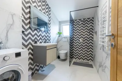 a bathroom with a sink and a washing machine at Modern apartment in a quiet area near the Airport in Golubovci