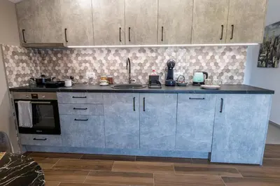 a kitchen with blue cabinets and a counter top at Modern apartment in a quiet area near the Airport in Golubovci