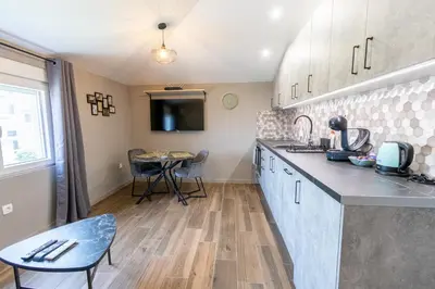 a kitchen with a counter and a table in it at Modern apartment in a quiet area near the Airport in Golubovci