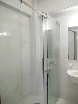 a glass shower in a bathroom with a sink at Urban apartments Sutomore in Sutomore