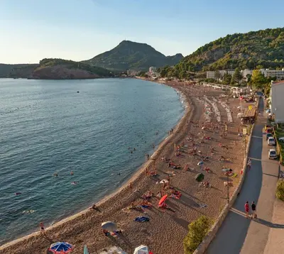 a beach with a lot of people in the water at Urban apartments Sutomore in Sutomore