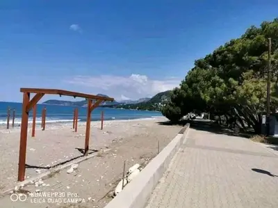 a beach with a wooden structure on the sand at Apartman Šušanj 2 in Bar