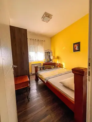 a bedroom with a bed and a yellow wall at Charming Countryside Villa with Garden & Terrace near Skadar Lake in Berislavci