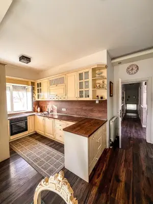 a kitchen with wooden cabinets and a counter top at Charming Countryside Villa with Garden & Terrace near Skadar Lake in Berislavci