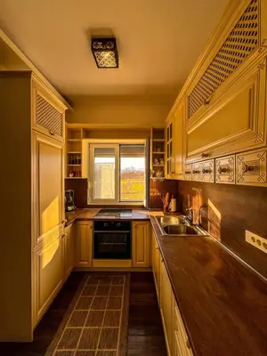 a kitchen with wooden cabinets and a sink and a window at Charming Countryside Villa with Garden & Terrace near Skadar Lake in Berislavci