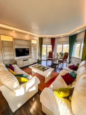 a living room with white couches and a tv at Charming Countryside Villa with Garden & Terrace near Skadar Lake in Berislavci