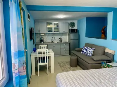 a small kitchen and living room with a couch and a table at Sutomore Panorama Studio in Sutomore