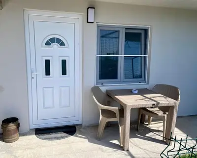 a table and chairs next to a white door at Sutomore Panorama Studio in Sutomore