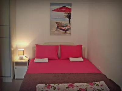 a bedroom with a red bed and a red umbrella at Kotor Kelly Apartments in Kotor