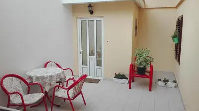 a patio with a table and chairs and a door at Kotor Kelly Apartments in Kotor