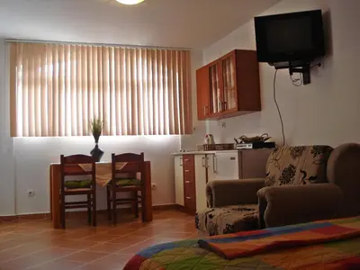 a living room with a table and chairs and a kitchen at Kotor Kelly Apartments in Kotor