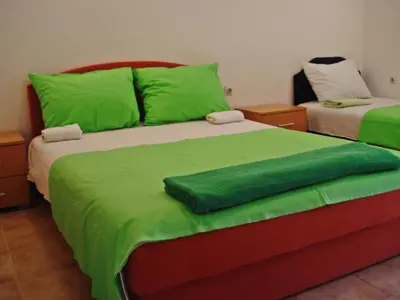 a bedroom with two beds with green sheets at Kotor Kelly Apartments in Kotor