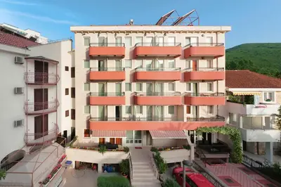 an apartment building with red balconies in a city at Apartments Ivona in Budva