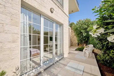 a patio with glass doors and a table and chairs at Villa Sofiia with panoramic views of the old town in Budva