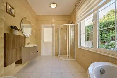 a bathroom with a sink and a shower and a mirror at Villa Sofiia with panoramic views of the old town in Budva