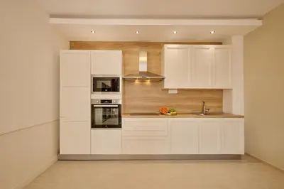 a kitchen with white cabinets and a sink at Villa Sofiia with panoramic views of the old town in Budva