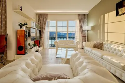a living room with a large couch and a large window at Villa Sofiia with panoramic views of the old town in Budva