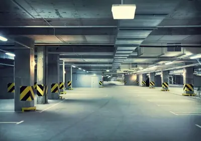 an empty parking garage with yellow and black caution signs at Central Lux in Podgorica