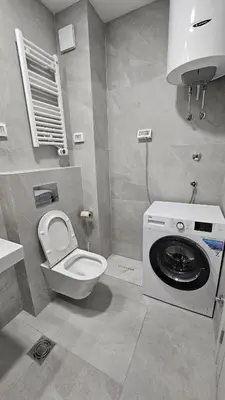 a bathroom with a washing machine and a toilet at Central Lux in Podgorica