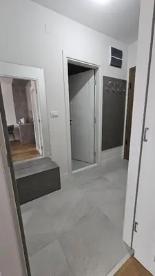 a room with a hallway with a door and a staircase at Central Lux in Podgorica