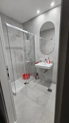 a bathroom with a shower and a sink and a mirror at Central Lux in Podgorica