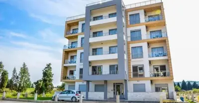 a white car parked in front of a building at Aria Apartman 1 Ulcinj in Ulcinj