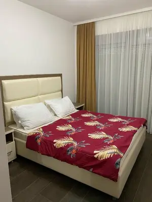 a bedroom with a large bed with a red blanket at Aria Apartman 1 Ulcinj in Ulcinj