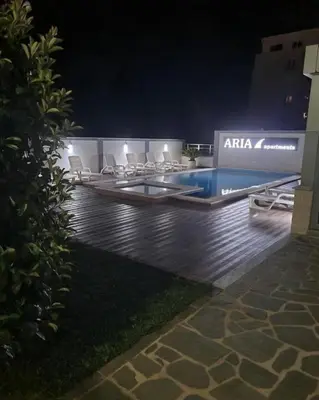 a group of chairs sitting around a pool at night at Aria Apartman 1 Ulcinj in Ulcinj