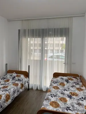 two beds in a room with a window at Aria Apartman 1 Ulcinj in Ulcinj