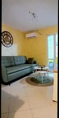 a living room with a blue couch and a table at Stan Rafailovici LM in Rafailovici