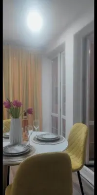 a dining room table with a vase of flowers on it at Stan Rafailovici LM in Rafailovici